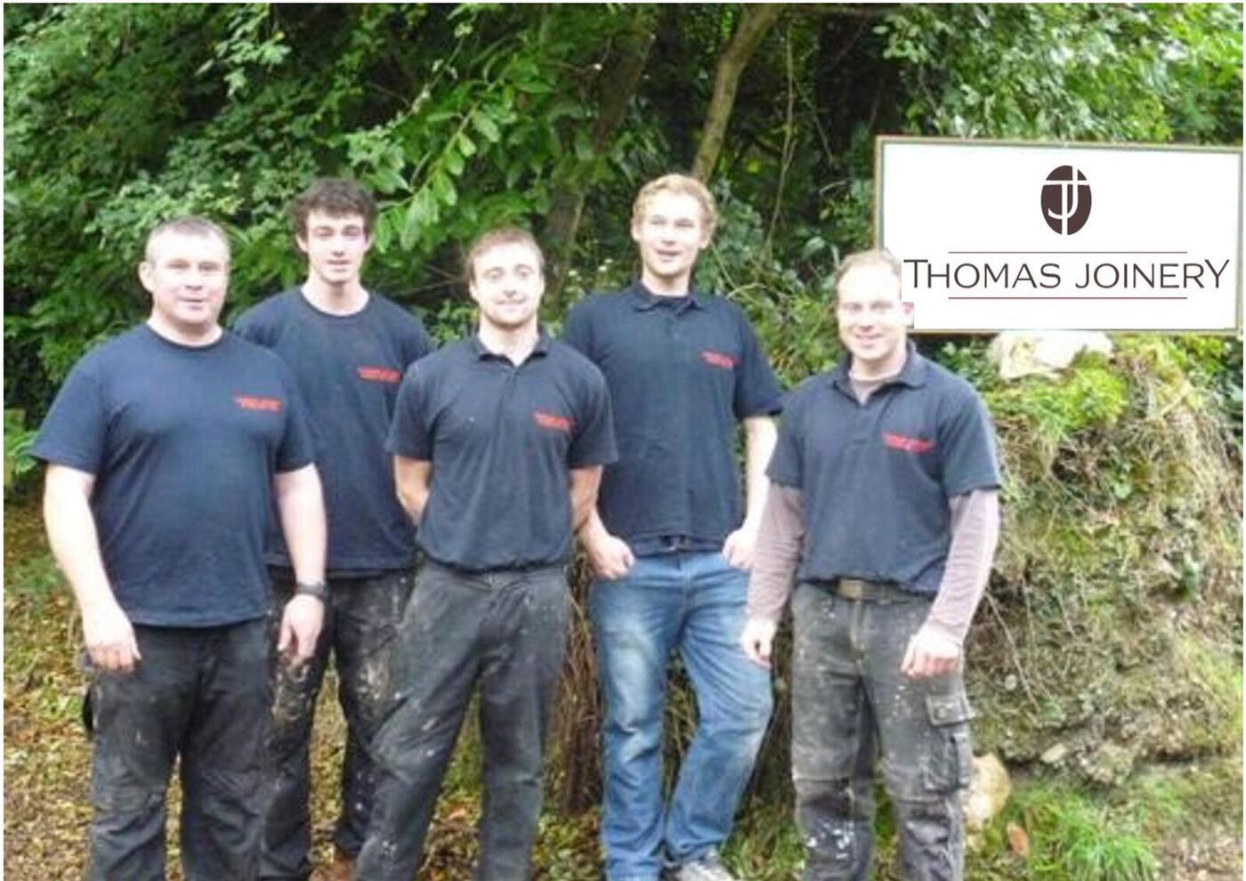 The Thomas Joinery team beside the company sign